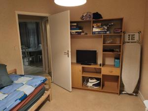 a bedroom with a bed and a desk with a television at Pavillon in Saint-Berthevin-sur-Vicoin
