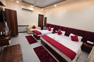 a hotel room with two beds and a couch at Kharari Inn in Ayodhya