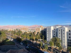 a view of a city with palm trees and buildings at 123Eilat panorama in Eilat
