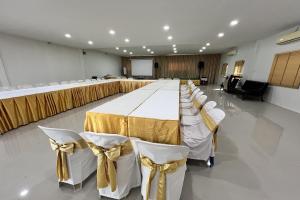 a large banquet hall with a long table with white chairs at Rabiangmai Resort in Ban Ko Krang