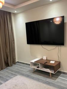 a living room with a flat screen tv on a wall at Sun capital stylish apartment in ‘Ezbet `Abd el-Ḥamîd