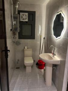 a bathroom with a toilet and a sink at Sun capital stylish apartment in ‘Ezbet `Abd el-Ḥamîd +6 photos