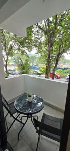 a table and chairs on a balcony with a window at Nala Host-Luxor studios in Male City