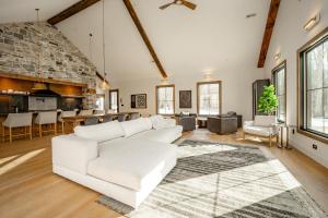 a living room with a white couch and a kitchen at Deep Creek Modern by Railey Vacations in Oakland
