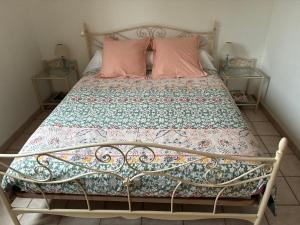 a bed with two pink pillows on top of it at Maisonette paisible à La Roque-Gageac in La Roque-Gageac +16 photos