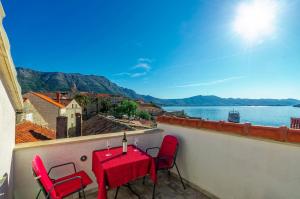 a table and chairs on a balcony with a view of the water at Apartments Lucija in Korčula +8 photos