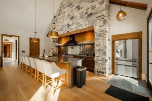 a kitchen with a stone wall and a bar with chairs at Deep Creek Modern by Railey Vacations in Oakland
