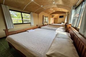 a row of beds in a room with windows at Rabiangmai Resort in Ban Ko Krang