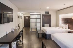 ein Hotelzimmer mit zwei Betten und einem Schreibtisch in der Unterkunft Unipark by Oro Verde Hotels in Guayaquil