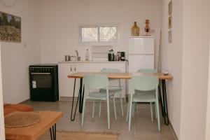 a kitchen with a table and chairs and a refrigerator at אירוח משק 42 in Sheʼar Yashuv