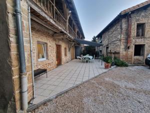 a patio outside of a brick building with a table at Chez Mémé in Sennecé-lès-Mâcon