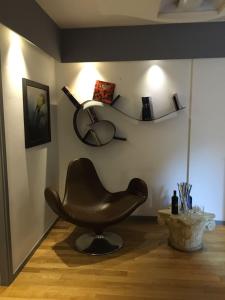 Indipendenza Boutique في بولونيا: كرسي بني جالس في غرفة بجانب جدار