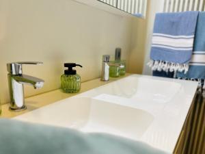 a white sink in a bathroom with a blue towel at Guesthouse Eekhoorn 16 in Kasterlee +38 photos