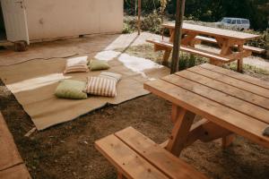 two pillows sitting on a wooden blanket next to a picnic table at אירוח משק 42 in Sheʼar Yashuv