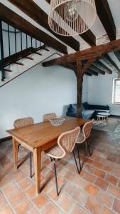 a dining room with a wooden table and chairs at Gîte du Noyer in Villexanton +5 photos