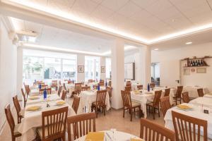 a dining room with white tables and chairs at Hotel leonardo in Cattolica