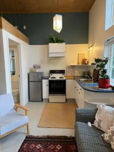 a kitchen with a couch and a stove top oven at Self-contained studio by the beach in Paekakariki