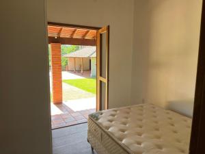 a bedroom with a bed and an open door at Recanto do Sossego in Gravataí
