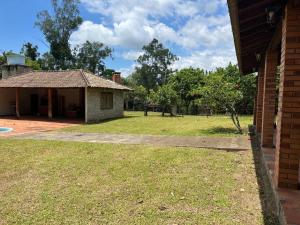 a house with a grass yard with a building at Recanto do Sossego in Gravataí