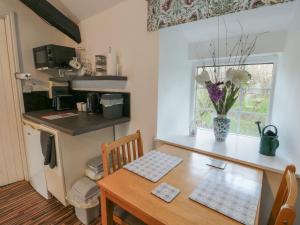a kitchen with a table and a small kitchen with a table and chairs at Fullers Studio in Holyhead