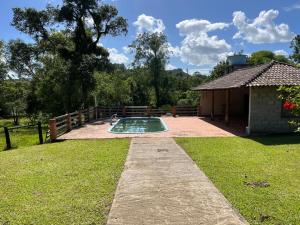 a swimming pool in a yard next to a building at Recanto do Sossego in Gravataí
