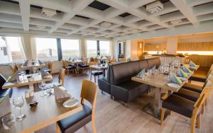 a restaurant with wooden tables and chairs and windows at Hótel Laugarbakki in Laugarbakki