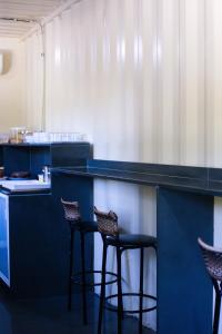 a blue counter with three chairs in a kitchen at Residencial Villa Container in Campinas