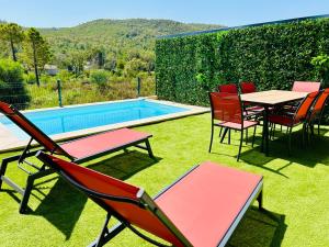 a patio with chairs and a table and a pool at Villa Corail- Piscine privée- Corsu di Core in Conca