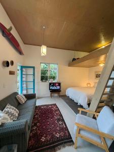 a living room with a bed and a couch at Self-contained studio by the beach in Paekakariki