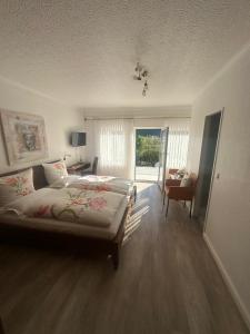 a bedroom with a large bed and a living room at Haus Marientaler Au GbR in Zell an der Mosel
