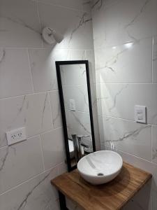 a white bathroom with a sink and a mirror at Casa Serena in Capitán Bermúdez