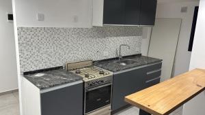 a small kitchen with a stove and a sink at Casa Serena in Capitán Bermúdez