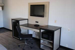 an office with a desk with a computer and a tv at legacy inn paducah in Paducah +11 photos