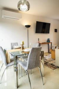 a living room with a glass table and chairs at AC Encanto in La Cisnera