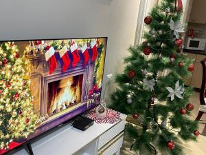a living room with a christmas tree and a television at Oaz Guest House Durres in Durrës