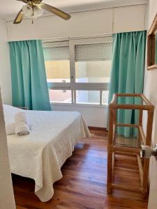 a room with a bed and a chair and a window at Edificio Carbe Punta del Este - Frente al Mar -parada 2 de la Mansa in Punta del Este