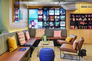 a waiting room with couches and a table and a shelf at Moxy Paris Bastille in Paris