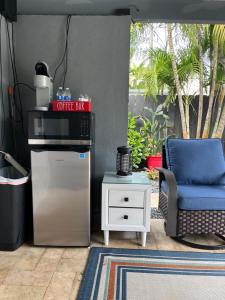 a coffee bar and a blue chair in a room at POOLSIDE MANOR - Men Only Clothing-Optional in Fort Lauderdale