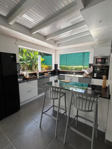 a kitchen with a table and two chairs in it at Villa Fleur de Lys MAE in Morne-à-lʼEau