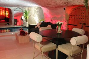 a living room with a table and a couch at L alcove des Sens Love Room Jacuzzi sauna in Tours