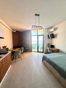 a hotel room with a bed and a desk and a table at Seafront Gonio Studio in Gonio