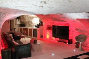 a living room with red lighting and a tv at L alcove des Sens Love Room Jacuzzi sauna in Tours