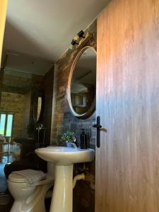 a bathroom with a sink and a mirror and a toilet at Konstantina 2 in Ayía Varvára