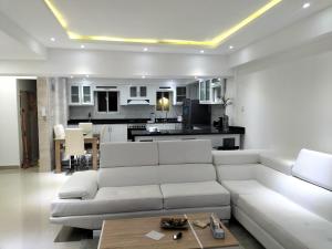 a living room with a white couch and a kitchen at Areito Apartament A&A in Juan López