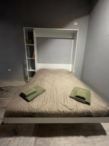 a bed with two green pillows on top of it at Monoambiente de Playa in Camarones