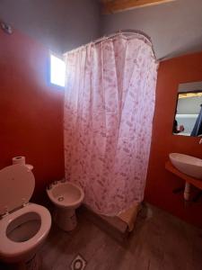 a bathroom with a pink shower curtain and a toilet at Monoambiente de Playa in Camarones