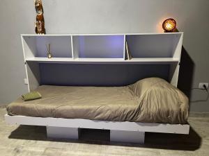 a bed with a white shelf and a bedvisor at Monoambiente de Playa in Camarones