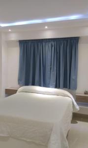 a bedroom with a window with a blue curtain at Areito Apartament A&A in Juan López +7 photos