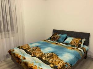 a bed with a leopard print blanket on it at La Sibip in Târgu Neamț +3 photos