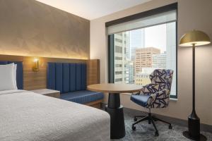 a hotel room with a bed and a table and a window at Hampton Inn By Hilton Calgary Downtown in Calgary +56 photos